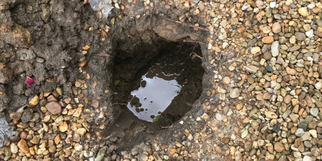 Hole Dug In Ground Due To Water Leak